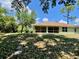 Lawn slopes down to a screen porch; mature trees visible on the property behind the house at 3721 Adelaide Ave, North Port, FL 34288