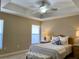 Bright bedroom featuring a ceiling fan, tray ceiling, and neutral wall color at 3721 Adelaide Ave, North Port, FL 34288