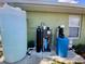 External view of the home's utility equipment, including water tanks and filtration systems at 3721 Adelaide Ave, North Port, FL 34288