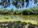 Scenic water view surrounded by lush trees, offering a serene and private setting at 3721 Adelaide Ave, North Port, FL 34288