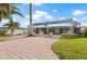 Extended brick paver patio with screened enclosure is surrounded by tropical landscaping at 441 Norma Ct, Punta Gorda, FL 33950