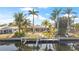 Waterfront home with boat lift and lush landscaping creating an inviting outdoor space by the canal at 441 Norma Ct, Punta Gorda, FL 33950