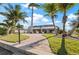 Paver path leading to a screened lanai, enhanced by tropical landscaping and mature palms at 441 Norma Ct, Punta Gorda, FL 33950