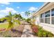 Landscaped walkway to the home entrance features vibrant flowers, palm trees, and inviting curb appeal at 441 Norma Ct, Punta Gorda, FL 33950