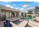 Inviting screened-in pool area with outdoor seating, a grill, and ample space for entertaining and relaxation at 441 Norma Ct, Punta Gorda, FL 33950