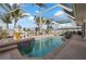 Enclosed pool area featuring a refreshing pool, tropical landscaping, and comfortable seating perfect for relaxation at 441 Norma Ct, Punta Gorda, FL 33950