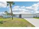 Charming home with a metal roof, lush lawn, mature palm trees, and a convenient two-car garage at 5194 Cooper Ter, Port Charlotte, FL 33981