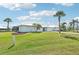 Desirable single-story home with a lush front lawn, mature palm trees, and a metal roof at 5194 Cooper Ter, Port Charlotte, FL 33981