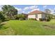 Well-manicured backyard with lush green lawn, landscaping, and an enclosed pool at 5428 Royal Poinciana Way, North Port, FL 34291