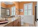 Well-lit bathroom featuring granite countertops, wood cabinetry, and a glass-enclosed shower at 5428 Royal Poinciana Way, North Port, FL 34291