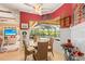Cozy dining area overlooks the pool and features wicker furniture and decorative wall art at 5428 Royal Poinciana Way, North Port, FL 34291