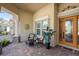 Inviting front porch featuring comfortable seating, brick flooring, and a stylish front door at 5428 Royal Poinciana Way, North Port, FL 34291