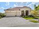 Beautiful single-story home with a red tile roof, a three-car garage, and a paved brick driveway at 5428 Royal Poinciana Way, North Port, FL 34291