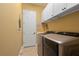 Laundry room featuring modern front load washer and dryer with upper cabinets at 5428 Royal Poinciana Way, North Port, FL 34291