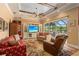 Bright living room with coffered ceiling, comfortable seating, and sliding glass doors to an outdoor patio at 5428 Royal Poinciana Way, North Port, FL 34291