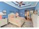 Well-lit main bedroom features a ceiling fan, blue walls, a decorative rug, and a sitting area at 5428 Royal Poinciana Way, North Port, FL 34291