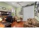 Inviting home office featuring wood floors, shutters, and a wall of Gathering photos at 5428 Royal Poinciana Way, North Port, FL 34291