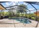 Gorgeous screened-in pool with spa, surrounded by lush landscaping for privacy at 5428 Royal Poinciana Way, North Port, FL 34291