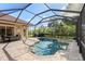 Relaxing screened-in pool area with spa, brick pavers, and dining set for outdoor living at 5428 Royal Poinciana Way, North Port, FL 34291