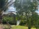 Picturesque backyard with lush greenery, trees, and a pathway leading to the water at 705 Crestview Nw Cir, Port Charlotte, FL 33948