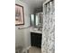 Well-lit bathroom featuring a single sink vanity with a marble countertop and floral-patterned shower curtain at 705 Crestview Nw Cir, Port Charlotte, FL 33948