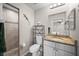 Well-lit bathroom featuring a granite vanity, toilet with storage, and tiled shower with pebble flooring at 7434 Ashtabula St, Englewood, FL 34224