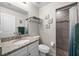Bathroom with granite countertop vanity, tiled shower, and convenient towel storage rack at 7434 Ashtabula St, Englewood, FL 34224
