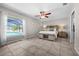 Cozy bedroom featuring a large window with pool view, ceiling fan, and neutral decor at 7434 Ashtabula St, Englewood, FL 34224