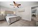 Comfortable bedroom with a ceiling fan, tiled flooring, and a view into an adjacent room at 7434 Ashtabula St, Englewood, FL 34224