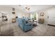 Spacious living room with blue sofas, vaulted ceilings, and views into the bedroom at 7434 Ashtabula St, Englewood, FL 34224