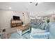 Comfortable living room with blue sofas, a TV, and an open view of the kitchen at 7434 Ashtabula St, Englewood, FL 34224