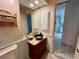 Charming bathroom featuring a vessel sink, a decorative mirror, and an adjacent doorway leading to another room at 1305 Alton Rd, Port Charlotte, FL 33952
