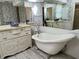 Elegant bathroom boasting a standalone tub, decorative wallpaper, and ample mirror space at 1305 Alton Rd, Port Charlotte, FL 33952