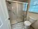 Bathroom featuring a glass-enclosed shower, toilet and neutral-toned tile work at 1305 Alton Rd, Port Charlotte, FL 33952