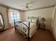 Comfortable bedroom with a ceiling fan, carpeted floors, natural light and stylish wrought iron bed frame at 1305 Alton Rd, Port Charlotte, FL 33952