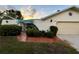 Charming single-story home with a unique architectural design, tidy landscaping, and brick walkway leading to the gate at 1305 Alton Rd, Port Charlotte, FL 33952