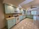 Spacious eat-in kitchen with light cabinets, white appliances, tiled floor, and plenty of natural light at 1305 Alton Rd, Port Charlotte, FL 33952
