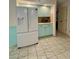 Well lit kitchen featuring a new refrigerator and mint-colored cabinets and drawers at 1305 Alton Rd, Port Charlotte, FL 33952