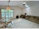 Bright living room featuring tile floors, a ceiling fan, and comfortable seating at 1305 Alton Rd, Port Charlotte, FL 33952