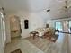 Open-concept living area with a decorative wall clock, neutral tones, and pool views at 1305 Alton Rd, Port Charlotte, FL 33952