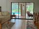 Bright living room showcasing a pool view through sliding glass doors, adjacent to the dining area at 1305 Alton Rd, Port Charlotte, FL 33952