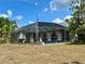 The pool enclosure sits in the backyard and has water views beyond at 1305 Alton Rd, Port Charlotte, FL 33952