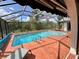 Screened pool area with a sparkling pool and brick patio at 1305 Alton Rd, Port Charlotte, FL 33952