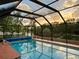 Sparkling swimming pool enclosed within a screened lanai, providing a relaxing and private oasis at 1305 Alton Rd, Port Charlotte, FL 33952