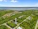 Panoramic aerial view of the home's location, nestled within a lush green neighborhood with water views in the distance at 13235 Essman Ave, Port Charlotte, FL 33953