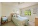 Cozy bedroom featuring a comfortable bed, chair, and natural light streaming through a window at 13235 Essman Ave, Port Charlotte, FL 33953