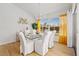 Bright dining room features a glass table, white chairs, light wood floors and plenty of natural light at 13235 Essman Ave, Port Charlotte, FL 33953