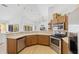 Bright kitchen features a breakfast bar, stainless steel appliances and access to both living room and dining room at 13235 Essman Ave, Port Charlotte, FL 33953