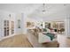 Open-concept living room boasts vaulted ceilings, hardwood floors, and an oversized couch with access to the pool at 13235 Essman Ave, Port Charlotte, FL 33953