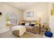 Cozy living room area with neutral colored couch, throw pillows, nearby side table and natural light at 13235 Essman Ave, Port Charlotte, FL 33953